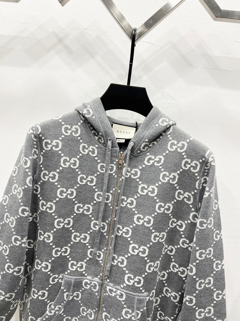Grey zip-up hoodie with allover monogram pattern and drawstring hood