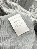 Gray knit garment care label stitched onto inside back of hood