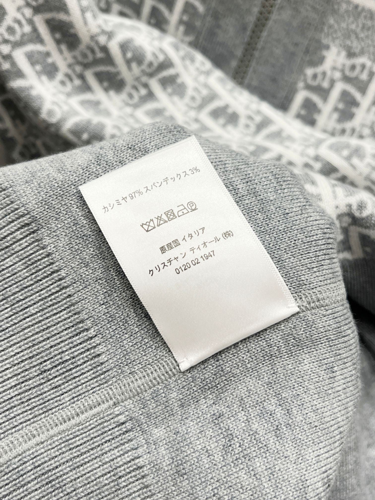 Gray knit garment care label stitched onto inside back of hood