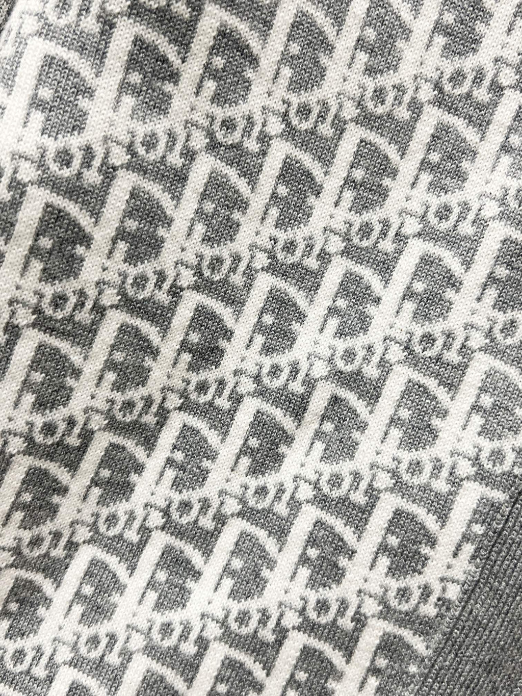Gray knit fabric with repeating Dior-style logo monogram pattern