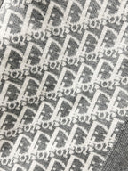 Gray knit fabric with repeating Dior-style logo monogram pattern