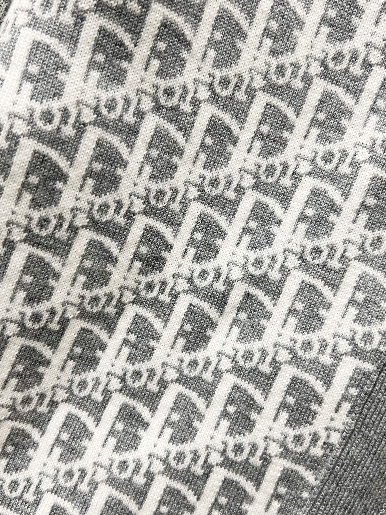 Gray knit fabric with repeating Dior-style logo monogram pattern