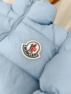 Light blue puffer jacket with Moncler logo crest patch on chest