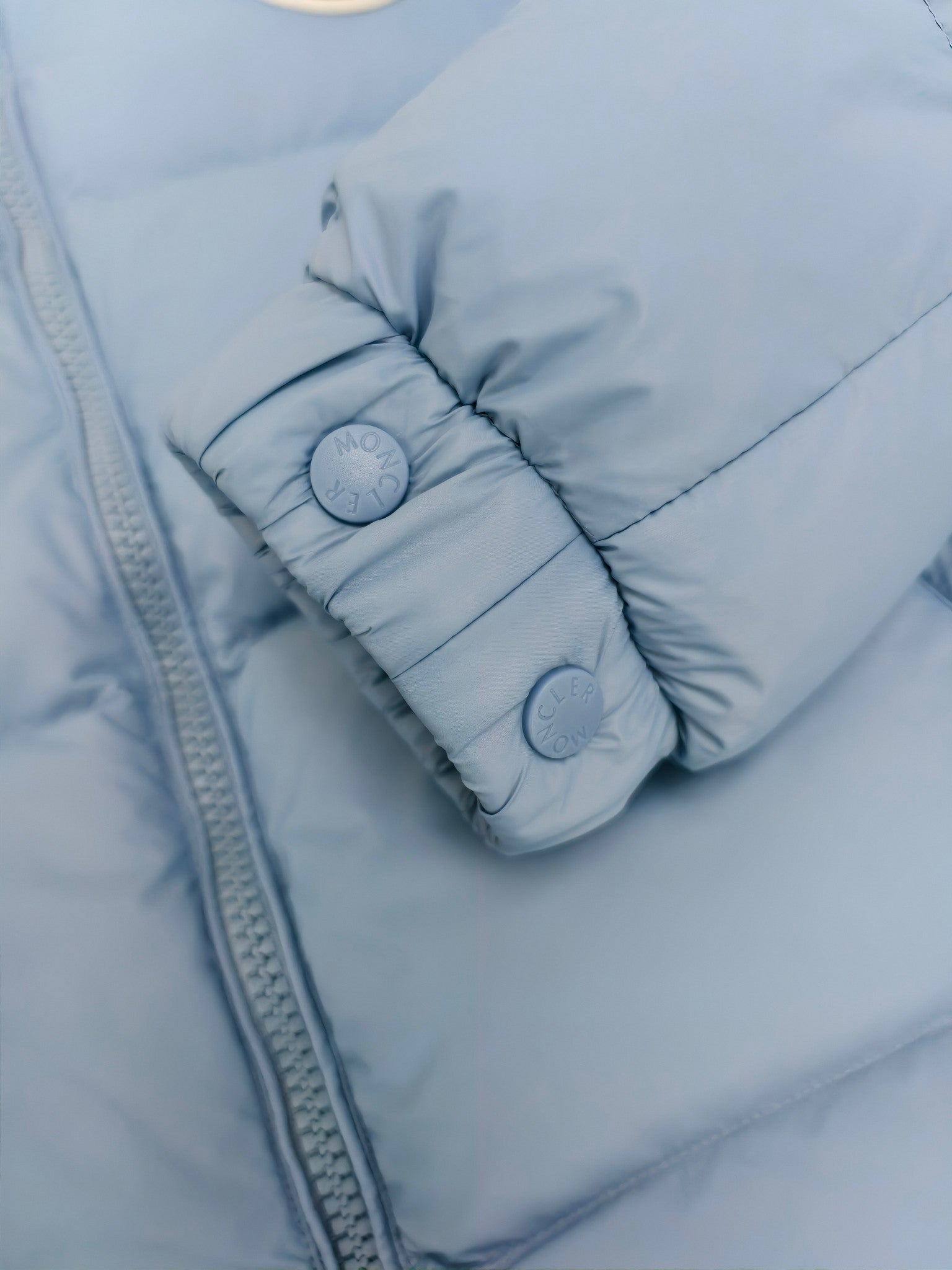 Light blue puffer jacket cuff with snap buttons and quilted padding