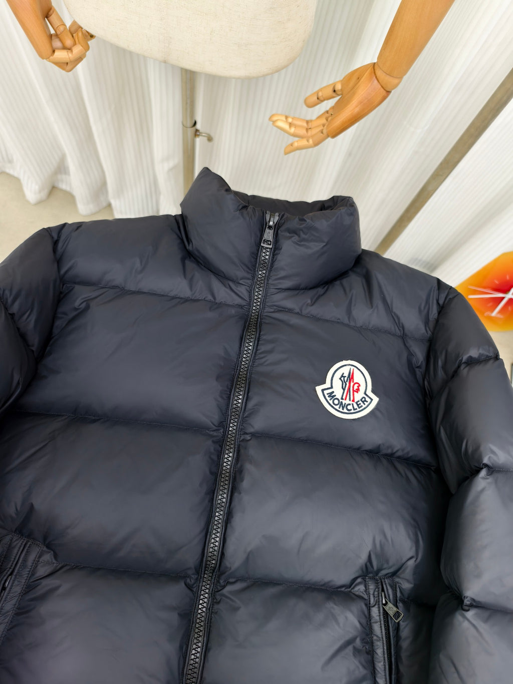 Moncler dark puffer jacket with stand collar, full zipper, and logo patch
