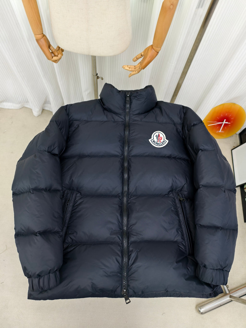 Moncler dark puffer jacket with full front zipper and embroidered logo patch