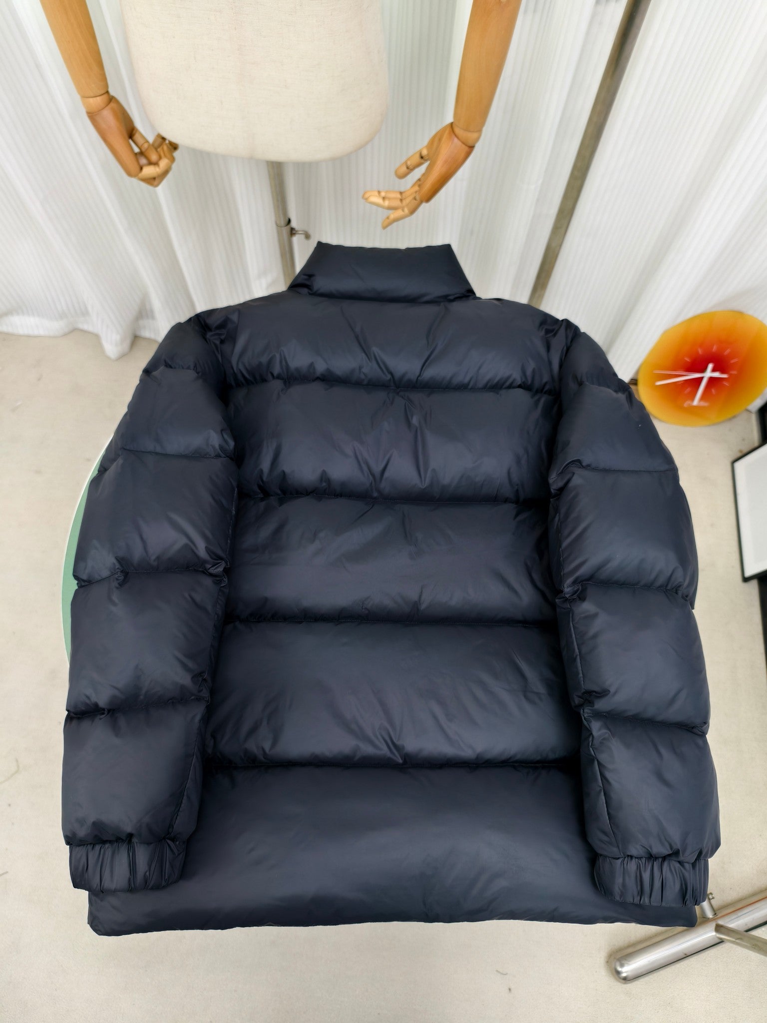 Moncler dark puffer jacket back view with horizontal quilting