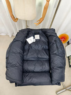 Moncler dark puffer jacket front view with stand collar and logo on chest