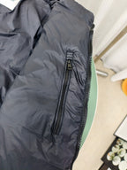 Moncler dark puffer jacket side view with zippered pocket and quilted texture