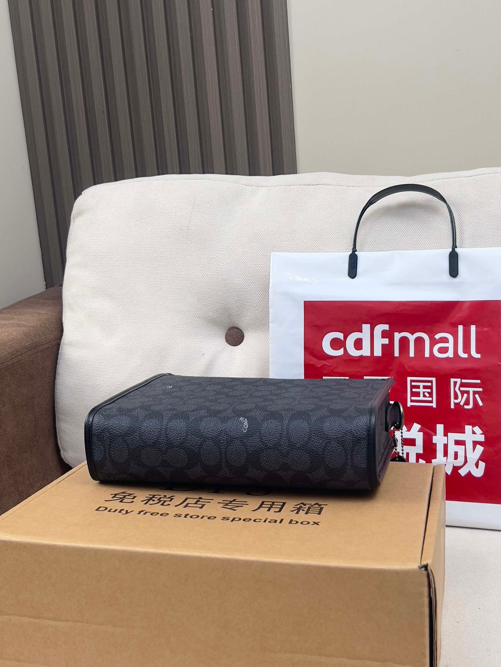 Dark navy patterned handbag clutch with top handle, placed on a box