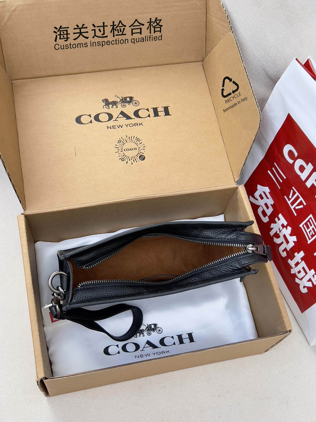 Dark navy crossbody bag set with zip pouch and strap, packed in a cardboard box