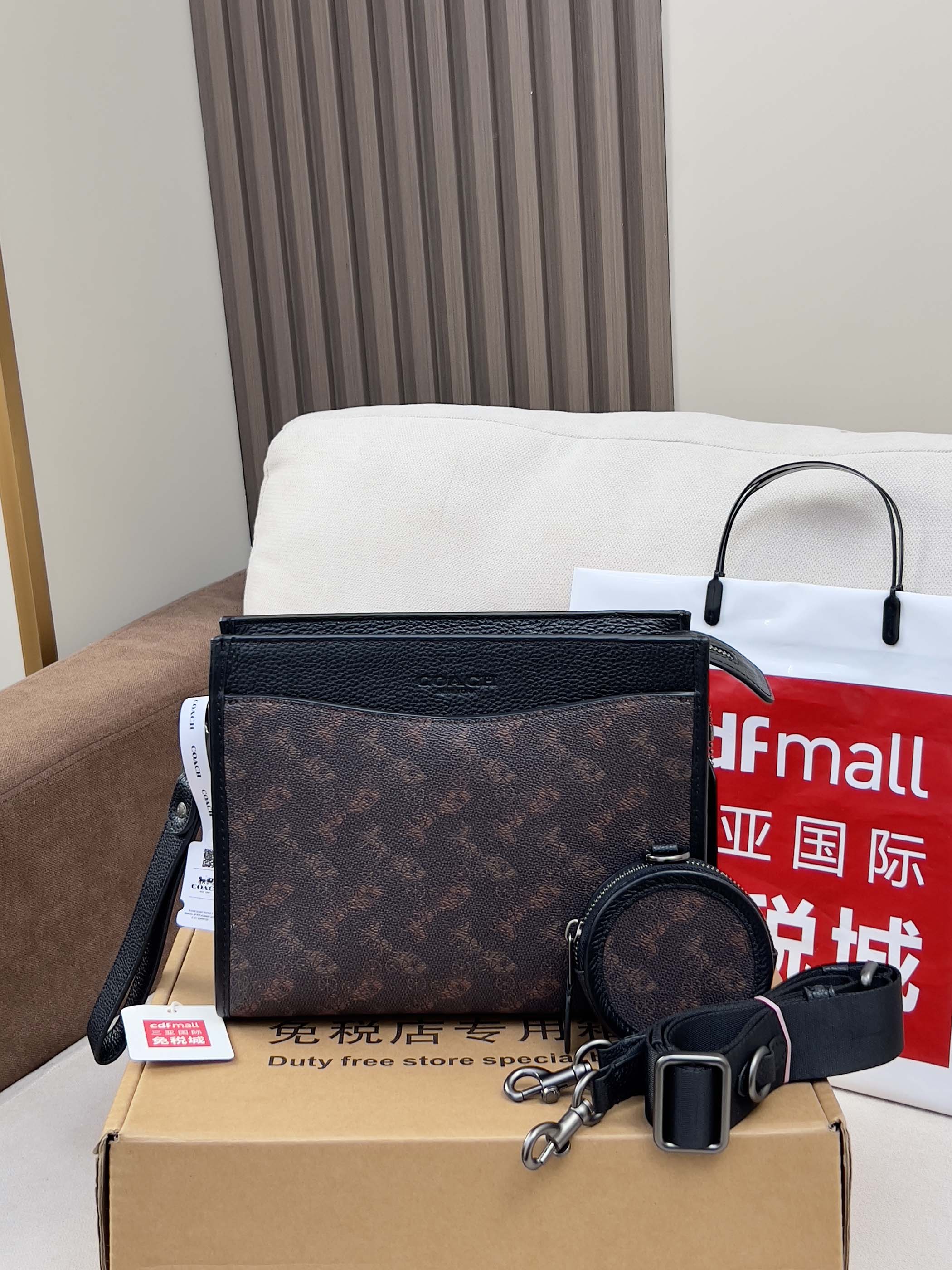 Dark monogram crossbody bag with zip top and round keychain charm