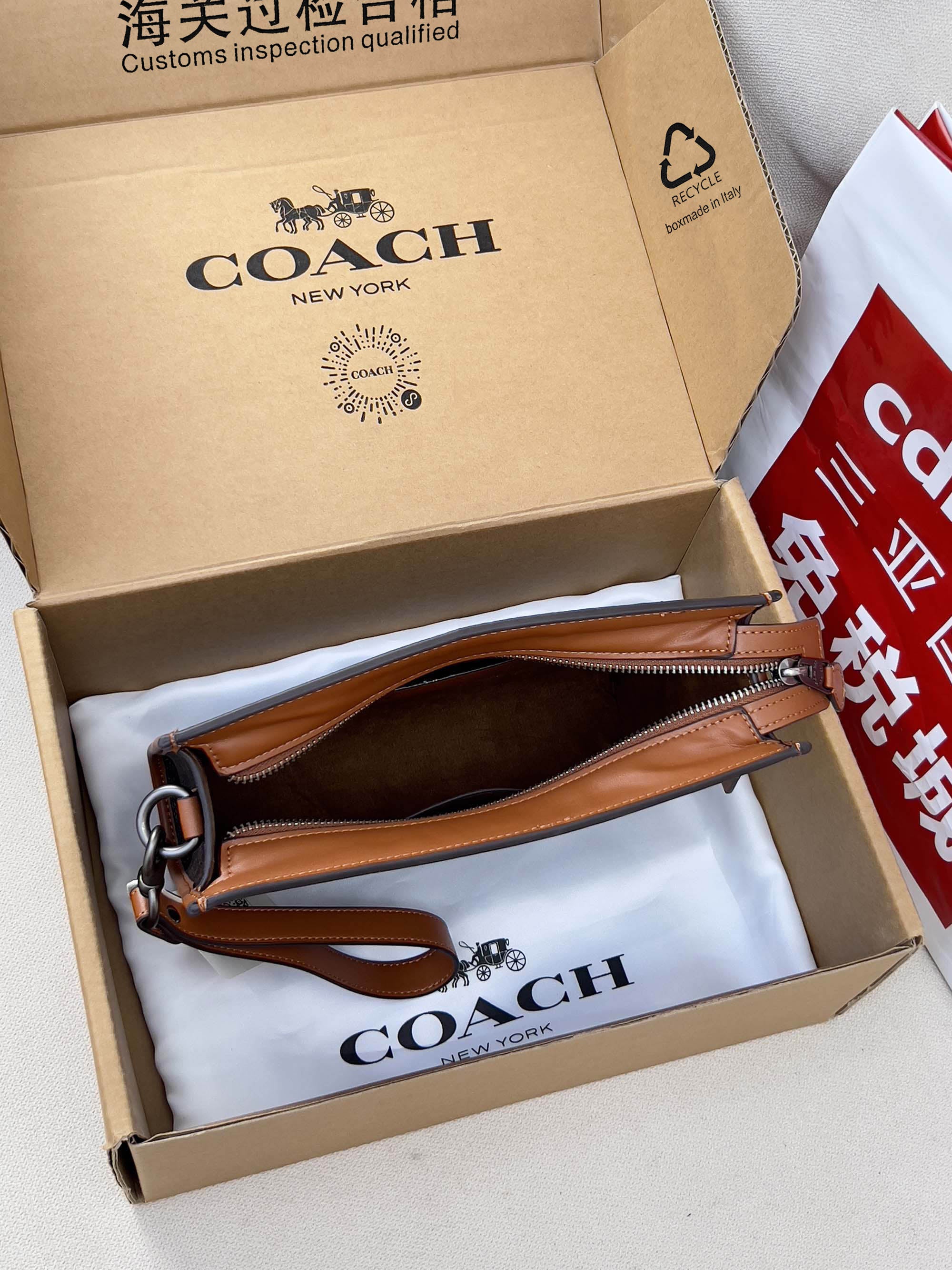Coah bag with dark monogram canvas, brown leather handle and wrist strap