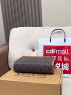 Coah bag with dark monogram fabric, brown trim, and top handle strap