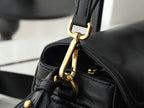 Black leather bag clasp with gold-tone hardware and zip pull