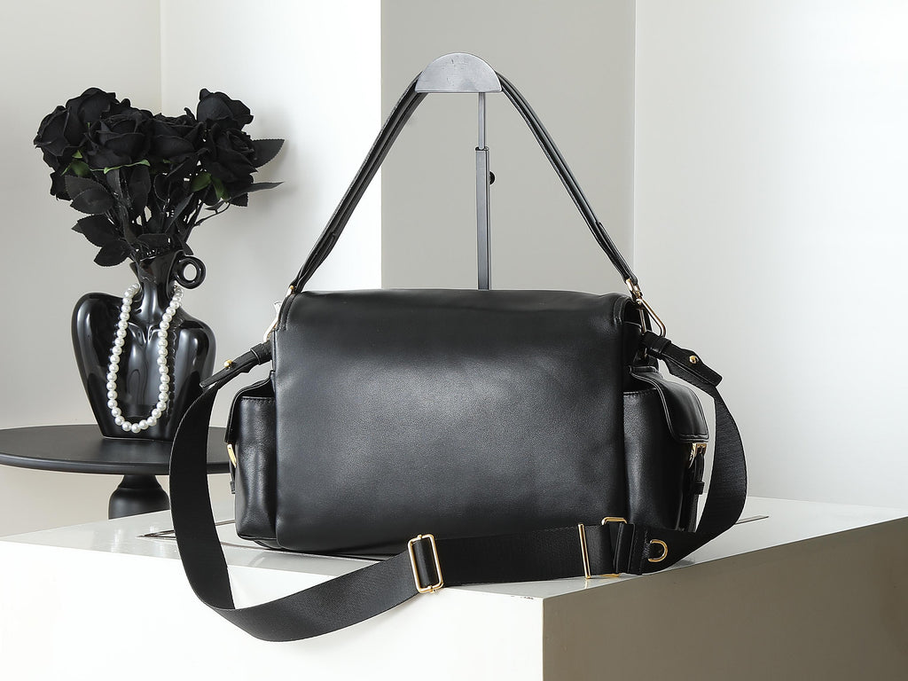 Black leather duffel-style bag with shoulder strap and gold hardware