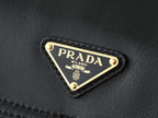 Black leather bag corner with triangular PRADA logo metal plaque