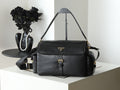 Black leather shoulder bag with flap, gold logo plaque, and adjustable strap
