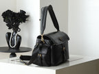 Black leather top-handle handbag with short handles and crossbody strap