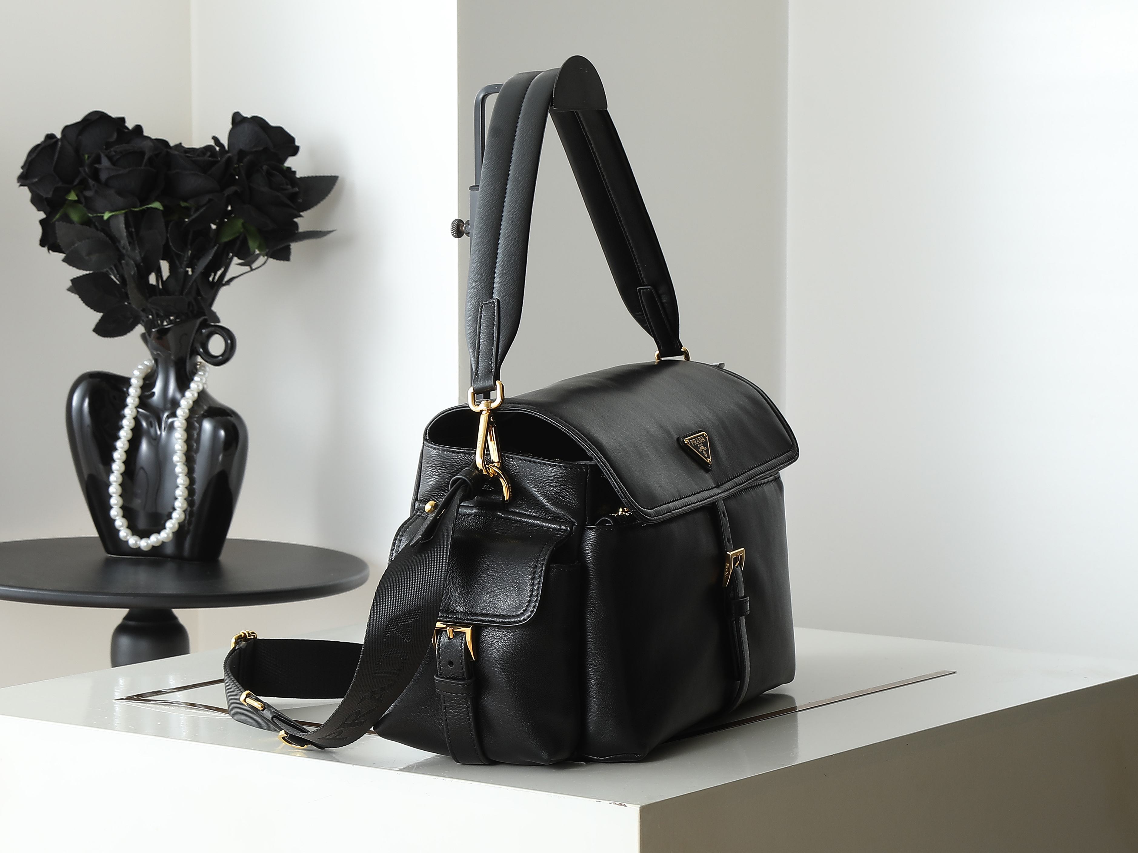Black leather top-handle handbag with short handles and crossbody strap
