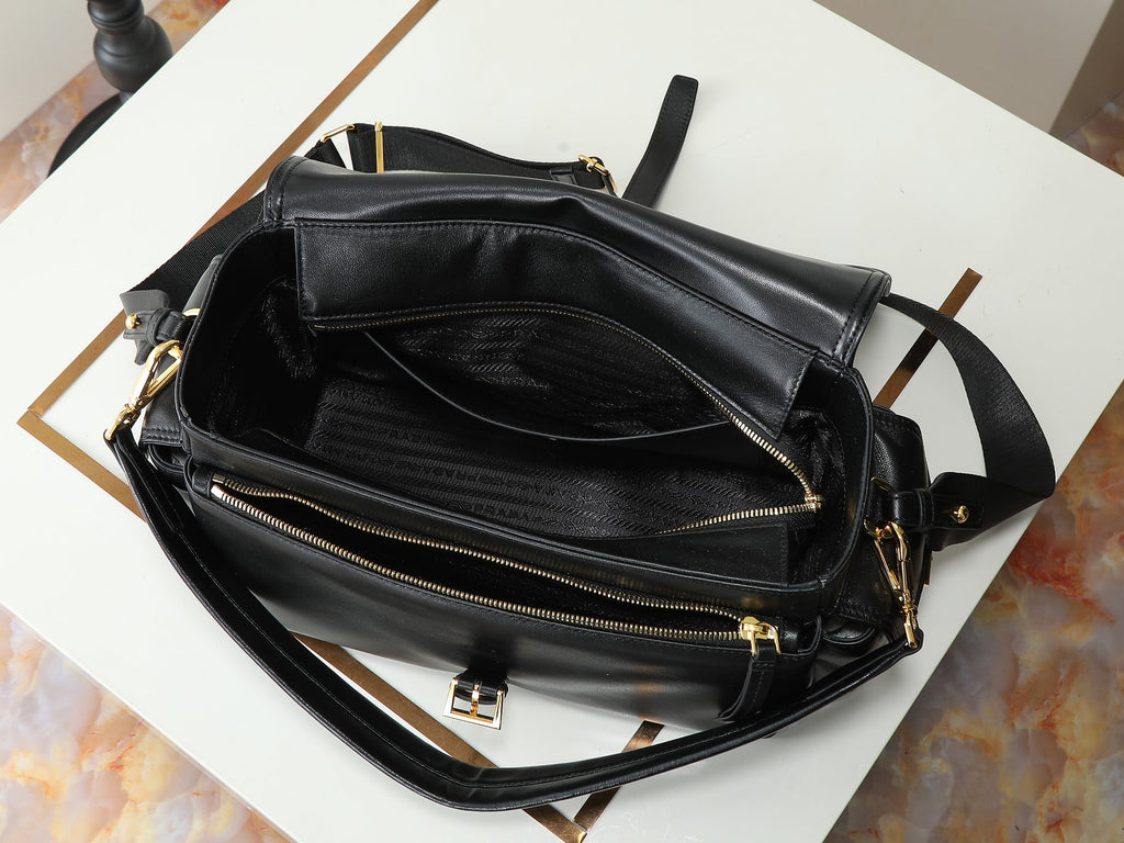 Black leather crossbody bag laid open with zip pockets and gold zippers
