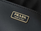 Black leather tag with gold trim reading PRADA and MADE IN ITALY
