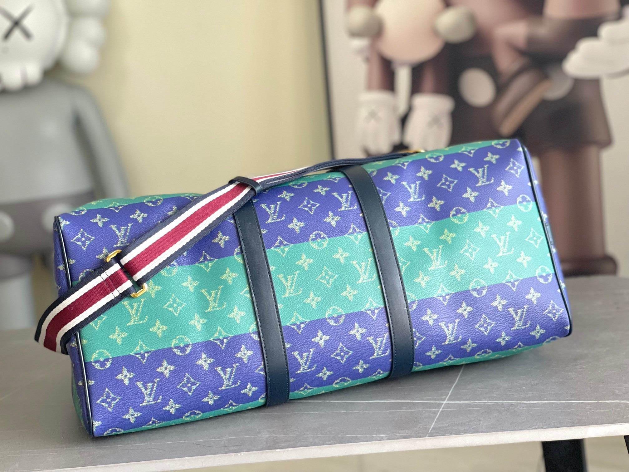 Louis Vuitton duffel bag with multicolor monogram and red-white striped strap, small pouch