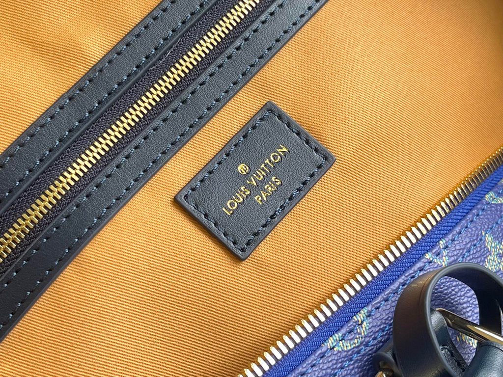 Louis Vuitton logo patch on interior lining with blue leather trim and gold zipper