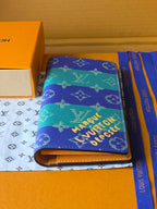 Small card holder with blue-and-teal monogram print, open edge and gold zipper pull