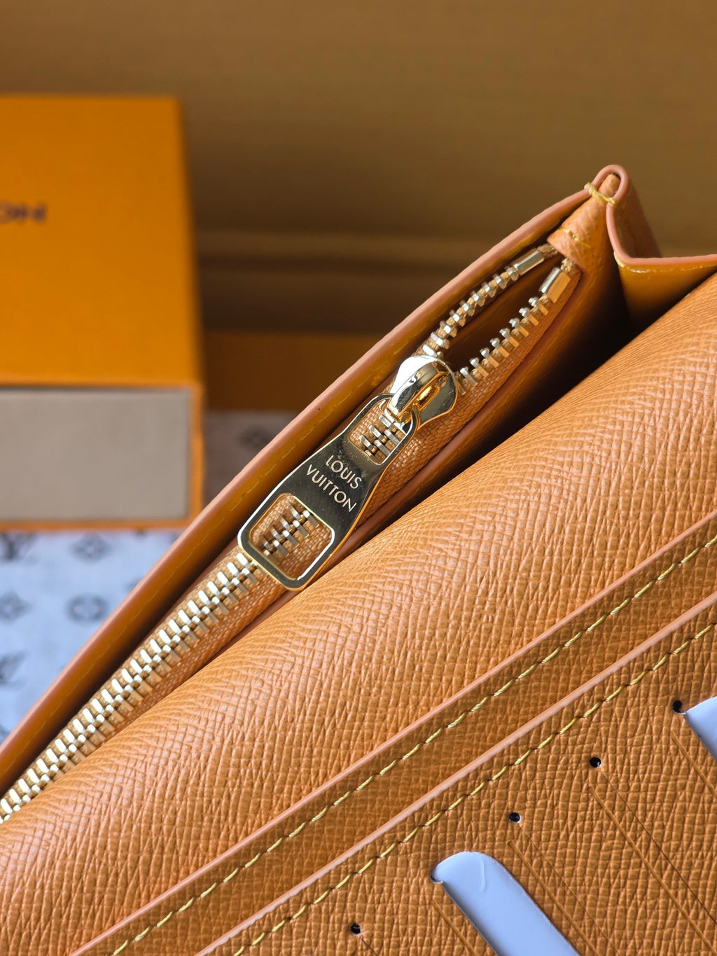 Small card holder interior close-up showing gold zipper and tan lining