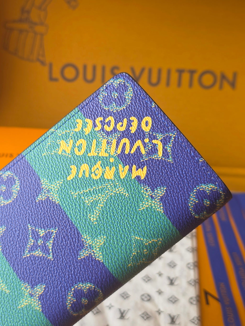 Small card holder top corner close-up with blue-and-teal monogram pattern