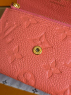 Louis Vuitton pink embossed leather with gold circular snap hardware