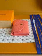 Louis Vuitton pink leather wallet, side view with snap flap and embossed pattern