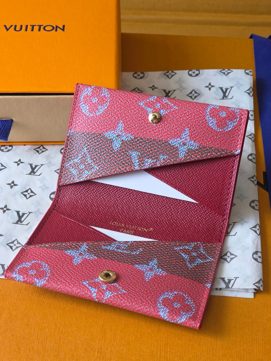 Louis Vuitton wallet with pink exterior and blue monogram, snap button and inner pocket.