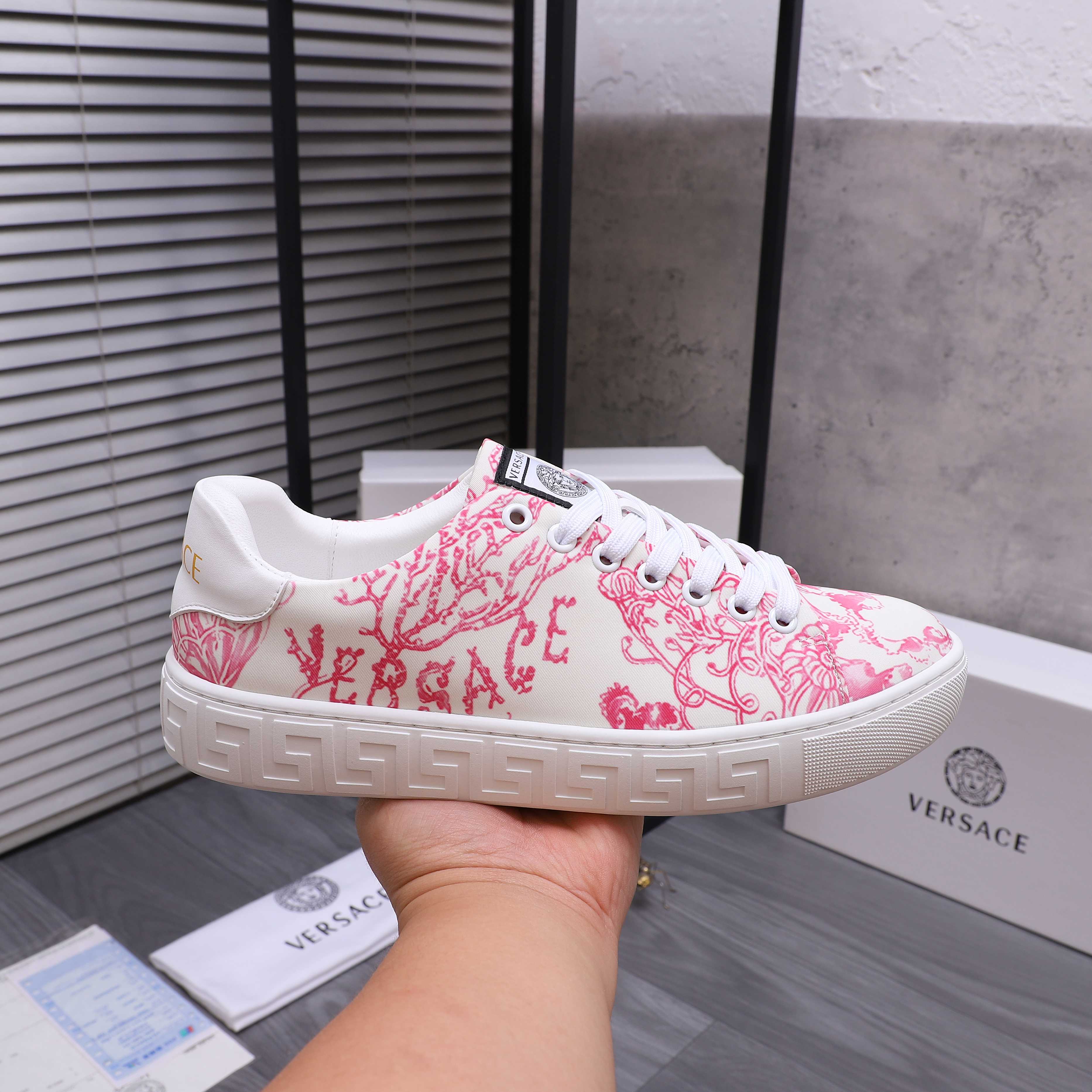 Pink and white patterned lace-up sneakers with white laces and rubber sole