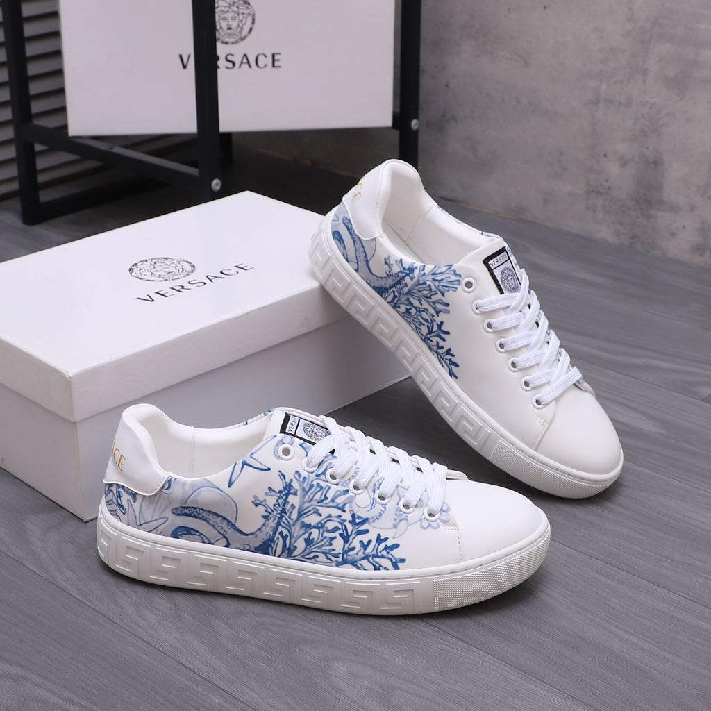 White low-top Versace sneakers with blue floral print, chunky rubber sole, lace-up.