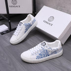 White Versace low-top sneakers with blue graphic print, lace-up, on shoe box.
