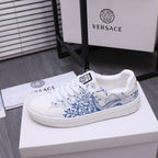 White Versace lace-up sneakers with blue graphic upper and textured rubber sole.