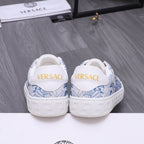 White Versace sneakers with blue pattern at heel, rear view, cushioned collar.