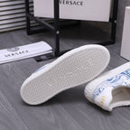 White Versace sneakers with blue uppers; textured outsole with repeating pattern.