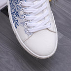 White Versace sneaker upper with blue botanical print and white laces, close-up.