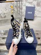 Dior unisex high-top sneakers in blue and beige with black laces, held in hand