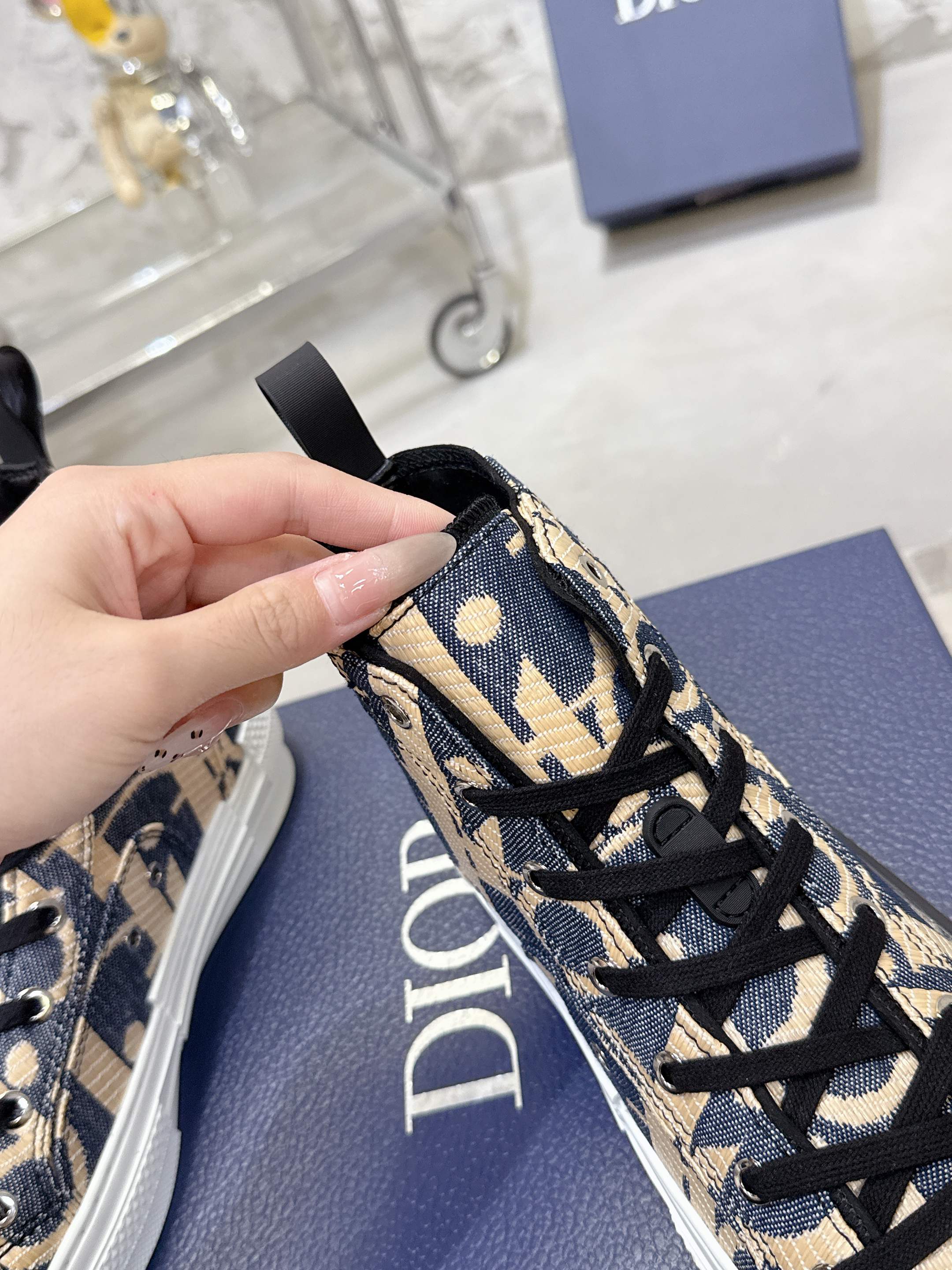 Dior unisex high-top sneaker close-up of patterned upper with black laces