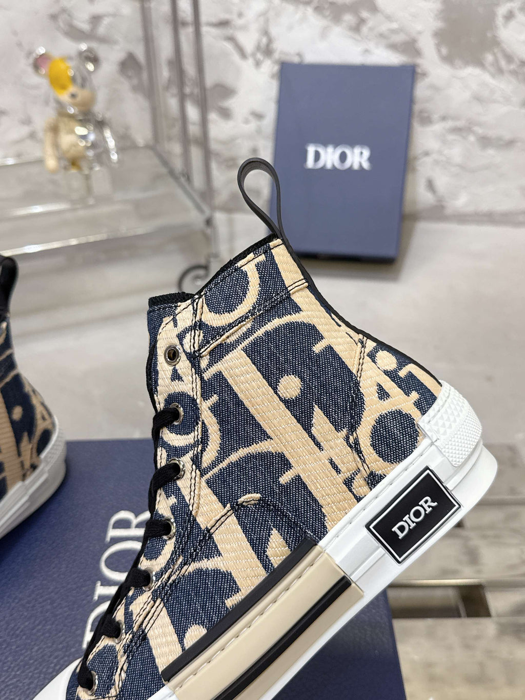 Dior unisex high-top sneaker side view with patterned canvas and black laces