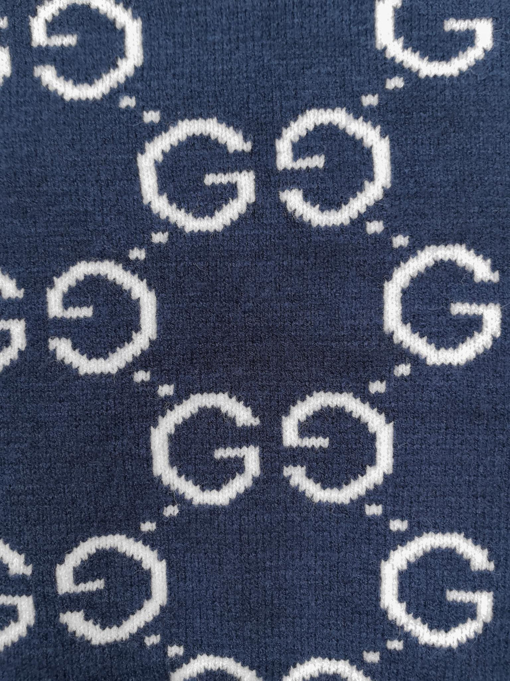 Navy knitted sweater close-up of repeating GG logo pattern