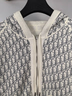 Zip-up hoodie close-up with monogram print, white hood lining, metal zipper
