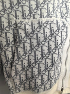 Monogram fabric panel detail on a zip-up hoodie, showing the zipper edge