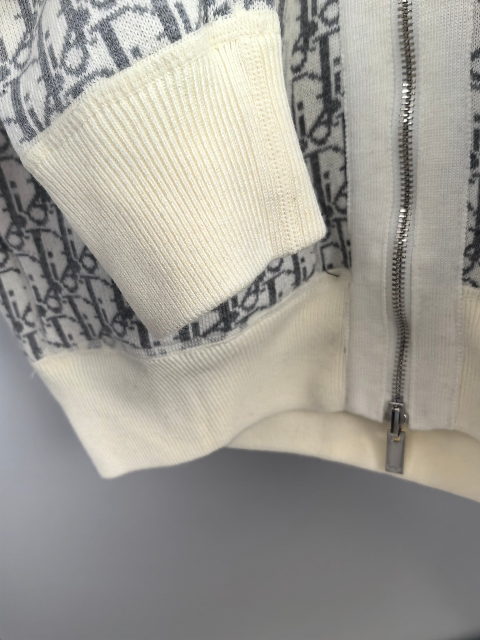 Close-up of off-white ribbed sleeve cuff and zipper on monogram hoodie