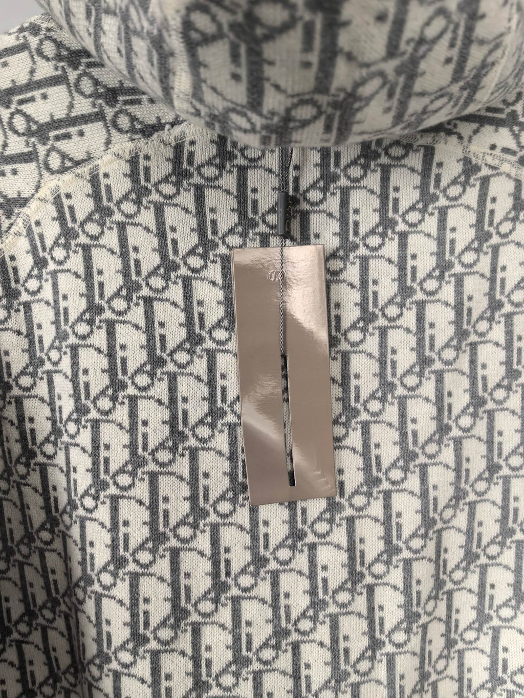 Monogram hoodie with hanging paper tag attached to the fabric