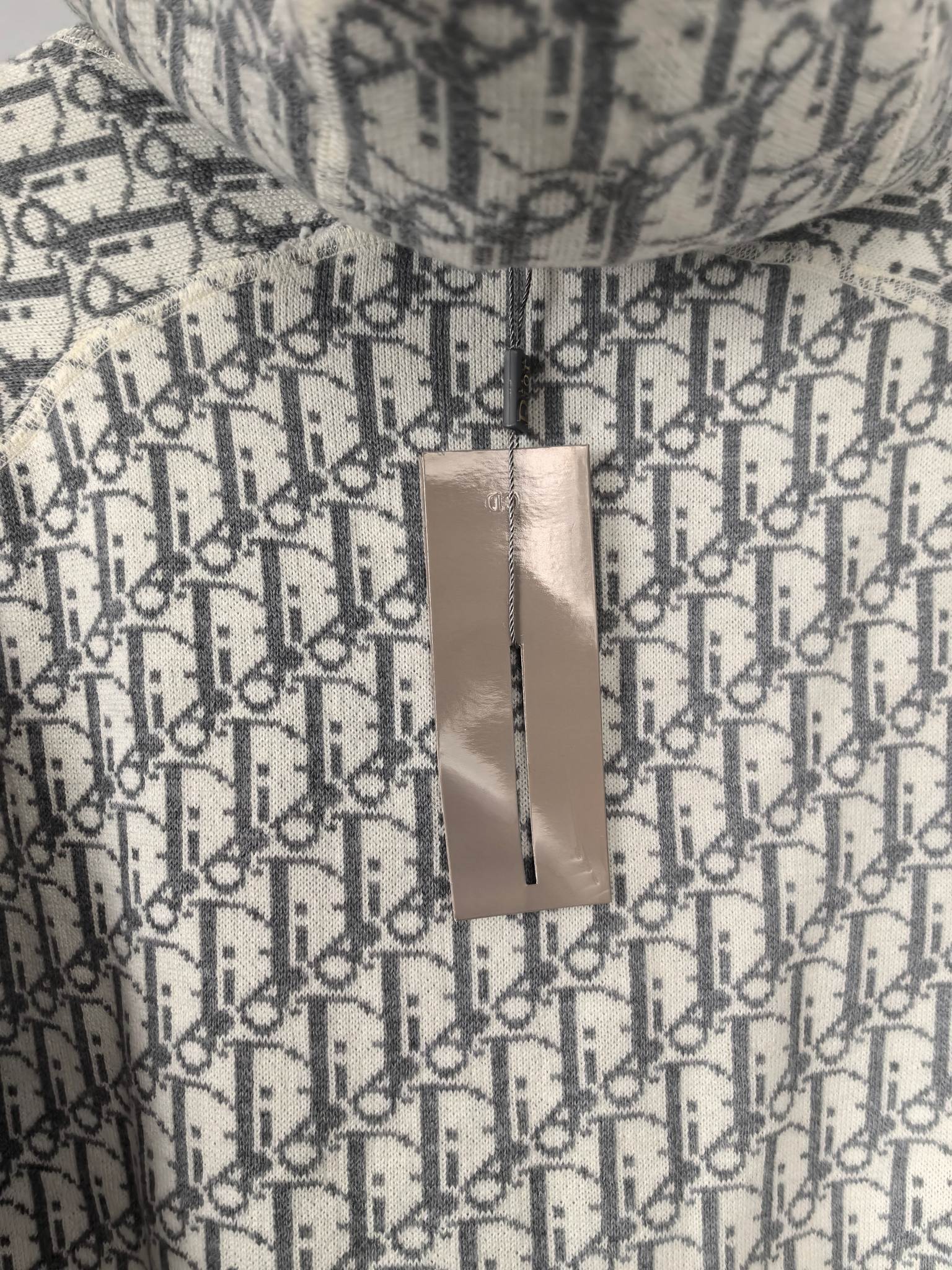 Monogram hoodie with hanging paper tag attached to the fabric